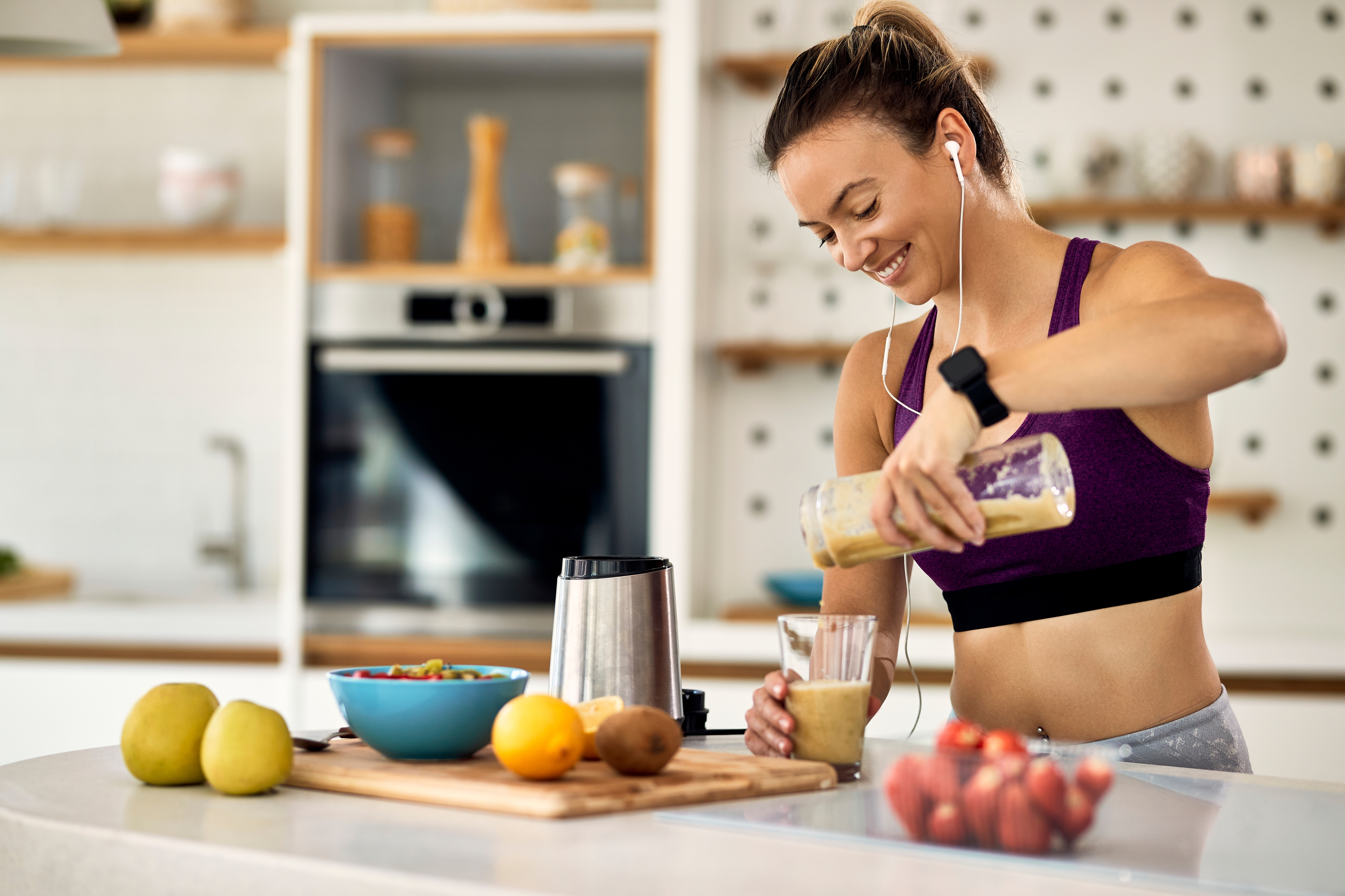 Mulher preparando shake proteico na cozinha